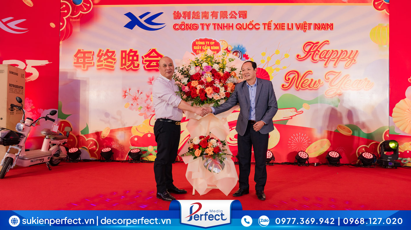 Đại diện lãnh đạo Công ty TNHH Quốc tế Xie Li Việt Nam lên sân khấu nhận những lẵng hoa tươi chúc mừng từ phía các đối tác/khách hàng.