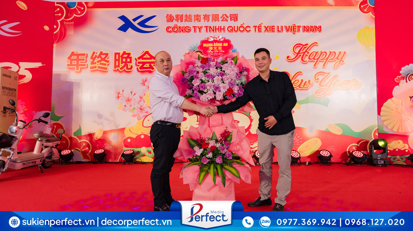 Đại diện lãnh đạo Công ty TNHH Quốc tế Xie Li Việt Nam lên sân khấu nhận những lẵng hoa tươi chúc mừng từ phía các đối tác/khách hàng.